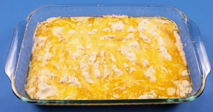 peaches in a cake pan with melted butter and white cake mix on top for easy peach cobbler dump cake recipe