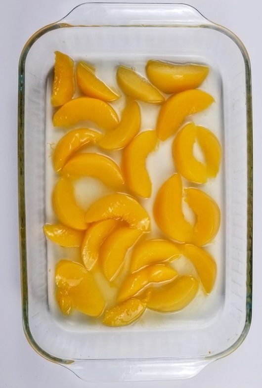 peaches in a cake pan for easy peach cobbler dump cake