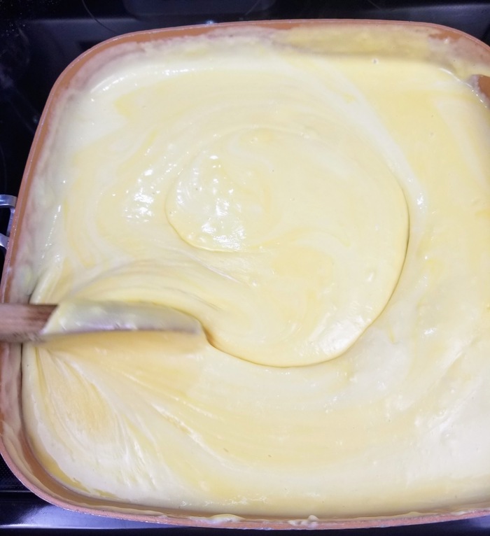 cheese sauce being stirred in a pan on a stovetop for cheeseburger soup recipe