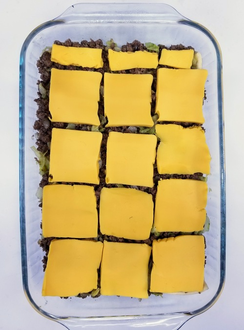 hamburger mixture with sliced velveeta in a cake pan