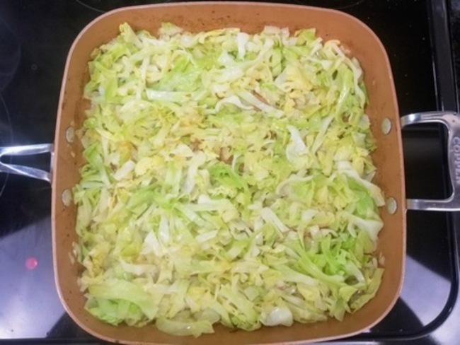 onions and green cabbage in a pan