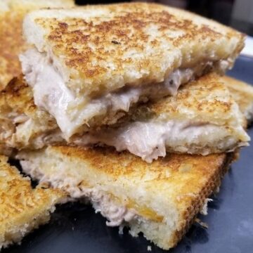 tuna melts stacked on a black plate