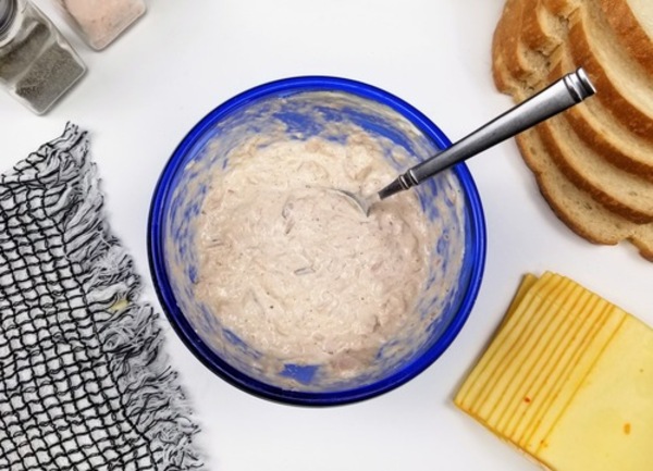 blue bowl with sour cream, mayo, tuna, cayenne, onion powder, and salt and pepper mixed together