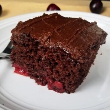 a piece of cherry chocolate cake on a white plate