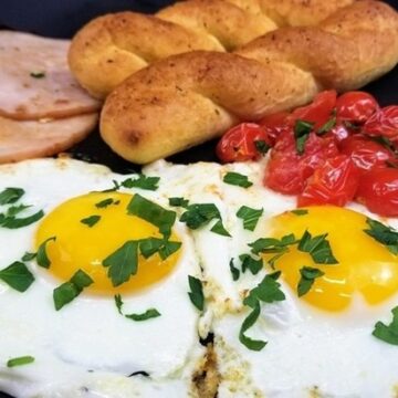 fried eggs in olive oil with cherry tomatoes