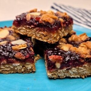 three cherry almond dessert bars on a blue plate